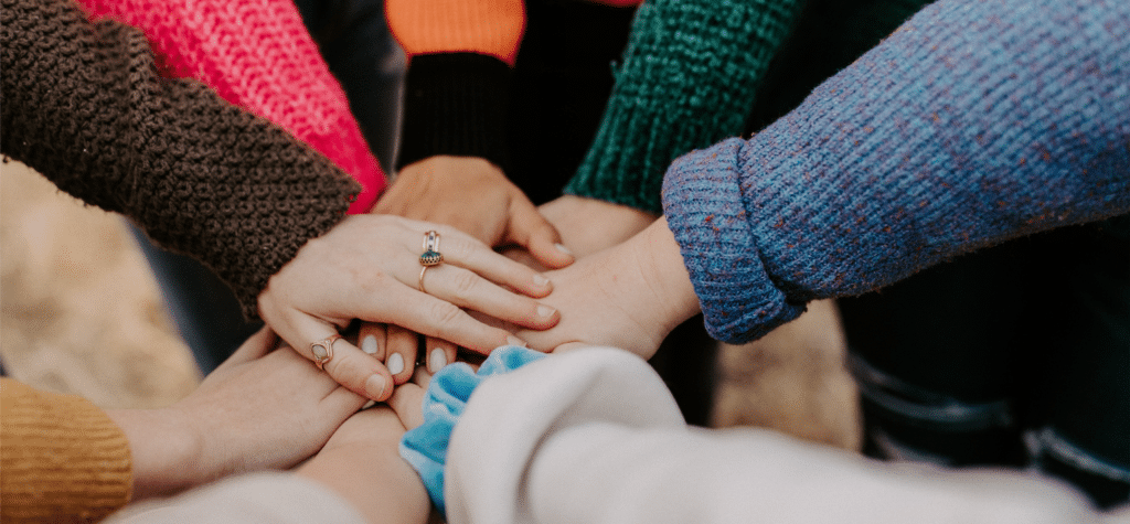 Hands in a group, enclosing in a circle.